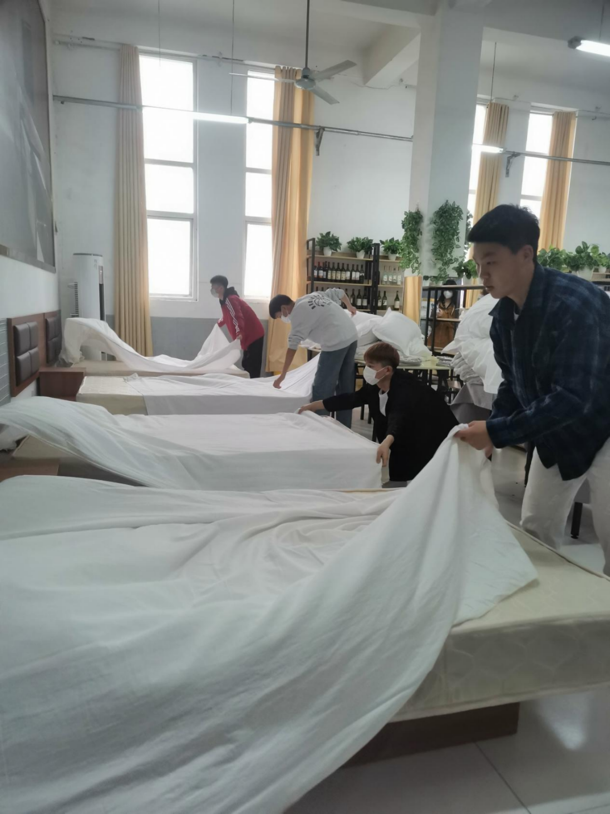 学生在酒店餐饮客房一体式实训室进行中式铺床练习 学生在酒店餐饮客房一体式实训室进行中式铺床练习