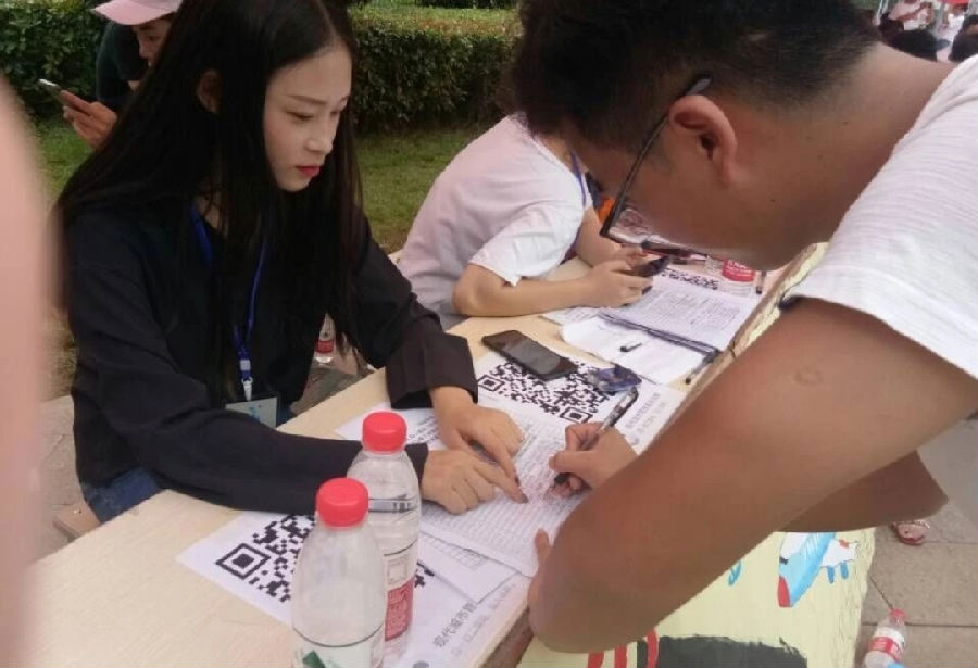 工作人员耐心指导新生填写报到表 工作人员耐心指导新生填写报到表