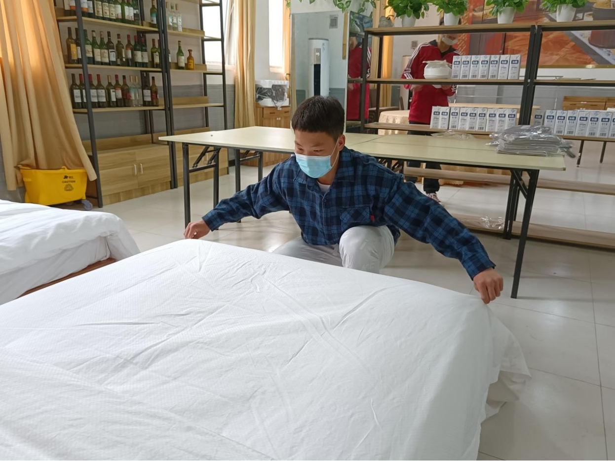 学生在酒店餐饮客房一体式实训室进行中式铺床练习 学生在酒店餐饮客房一体式实训室进行中式铺床练习